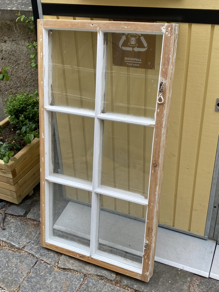 Restaurerat spröjsfönster lutat mot gul vägg