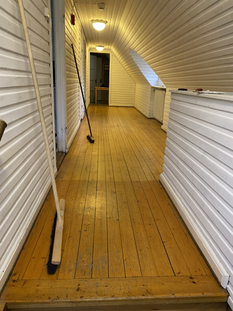 Nymålad vindskorridor med plankgolv