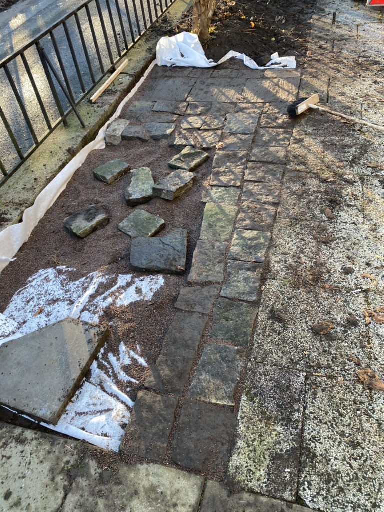 Markplattor lyfts och repareras vid gångvägen