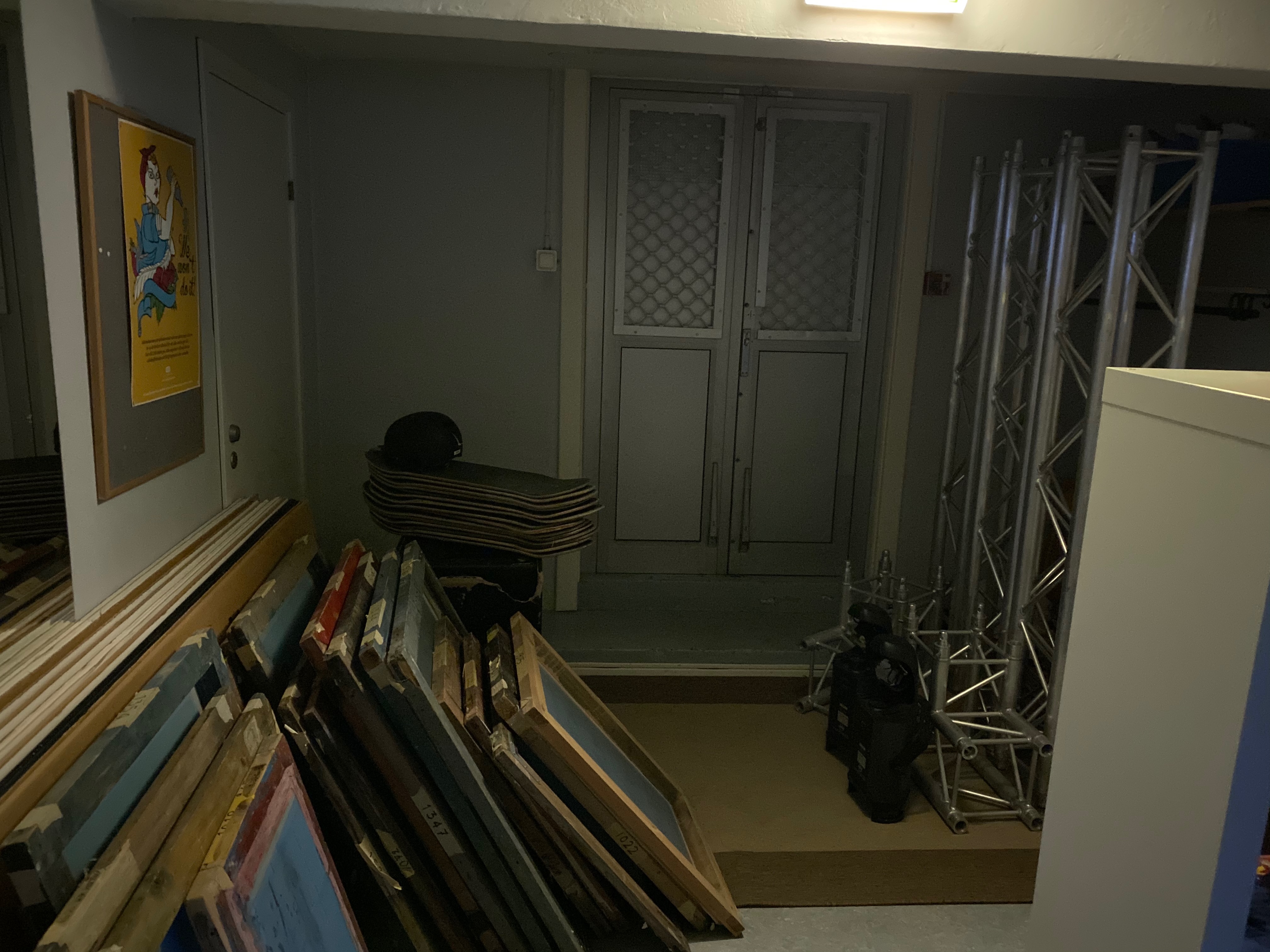 Mörkt källarförråd med tavlor och gamla dörrar