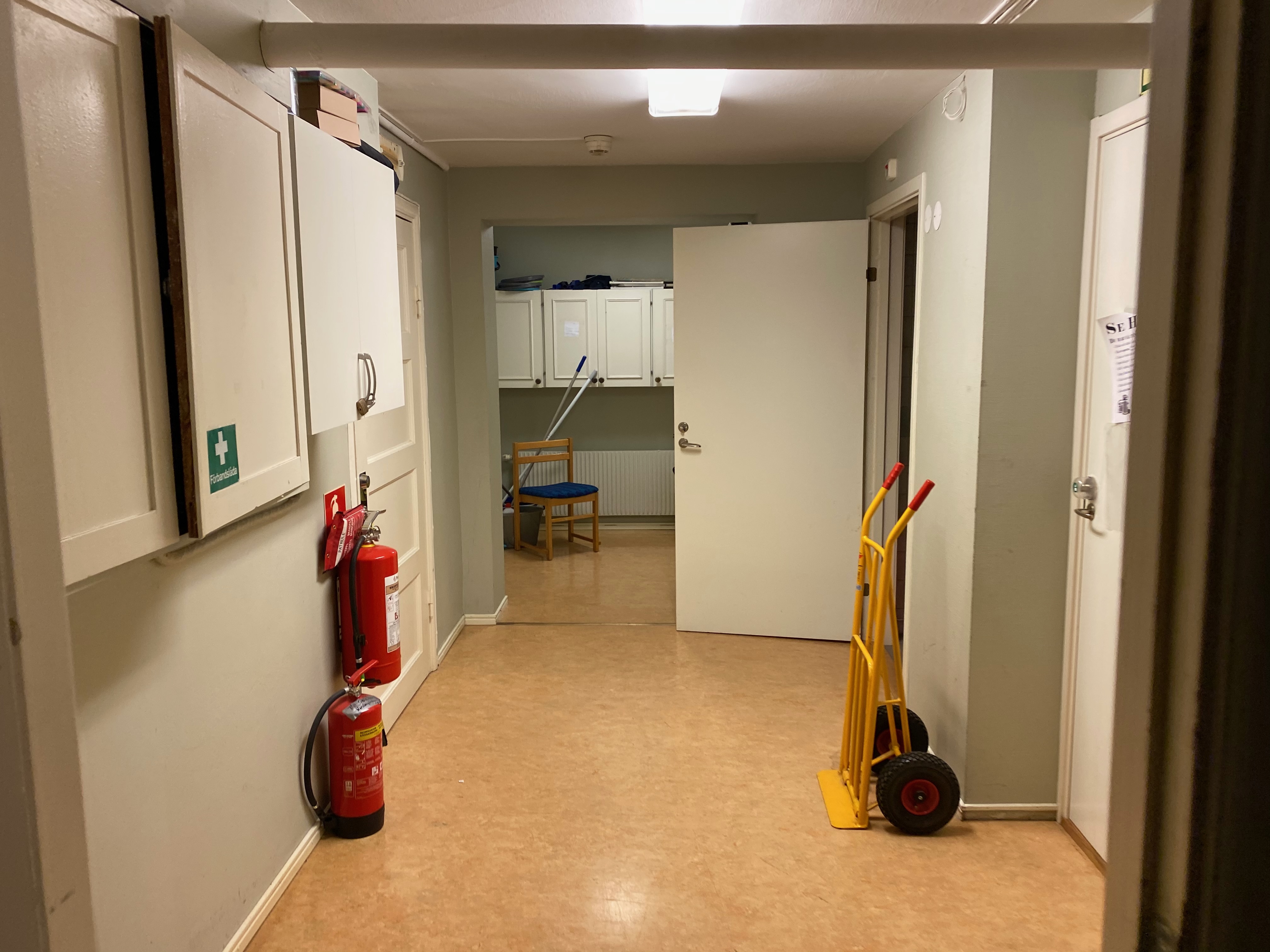 Korridor med brandsläckare och säckkärra