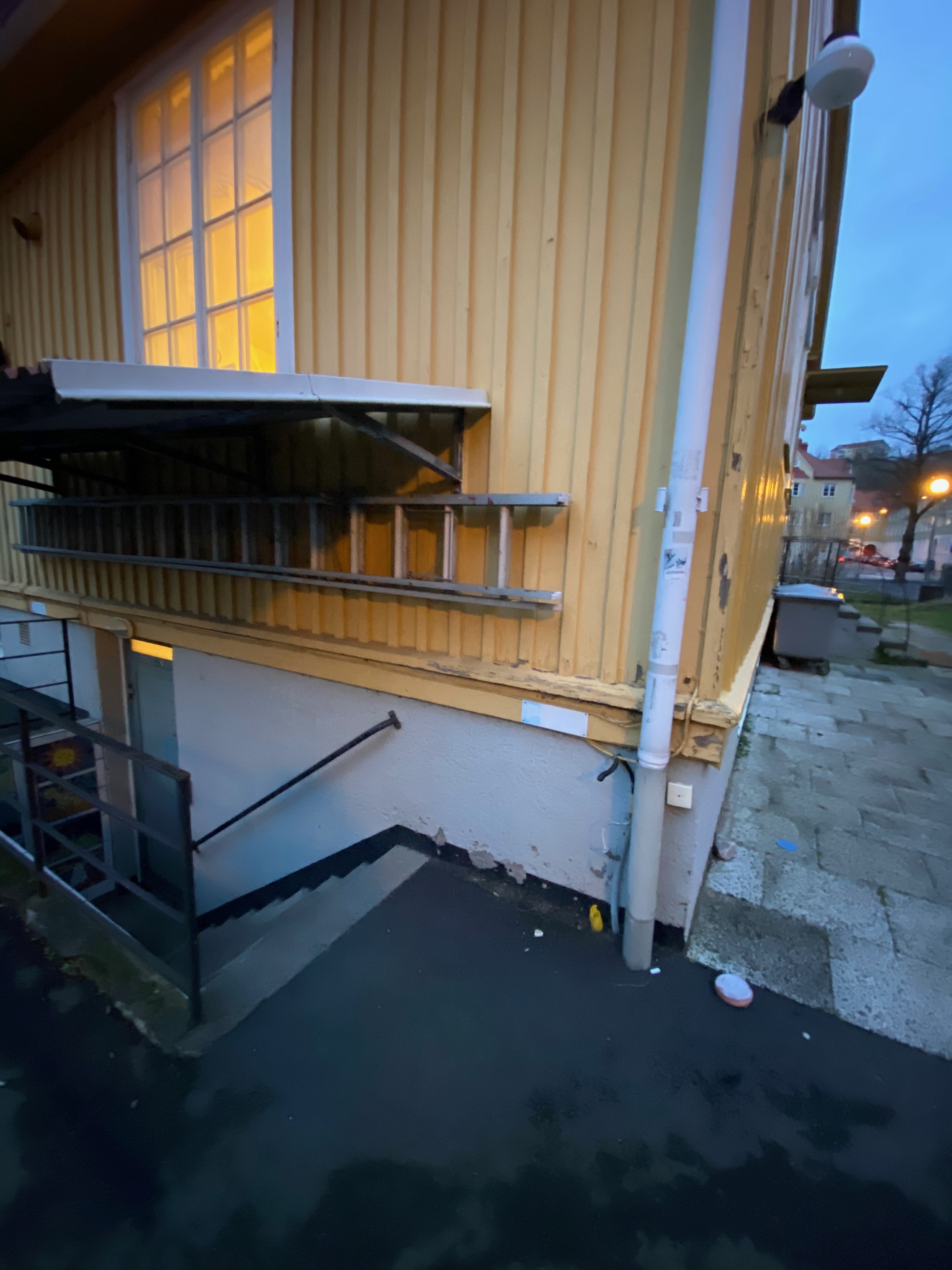 Halvmånefönster och vittrad trappa vid källaringång