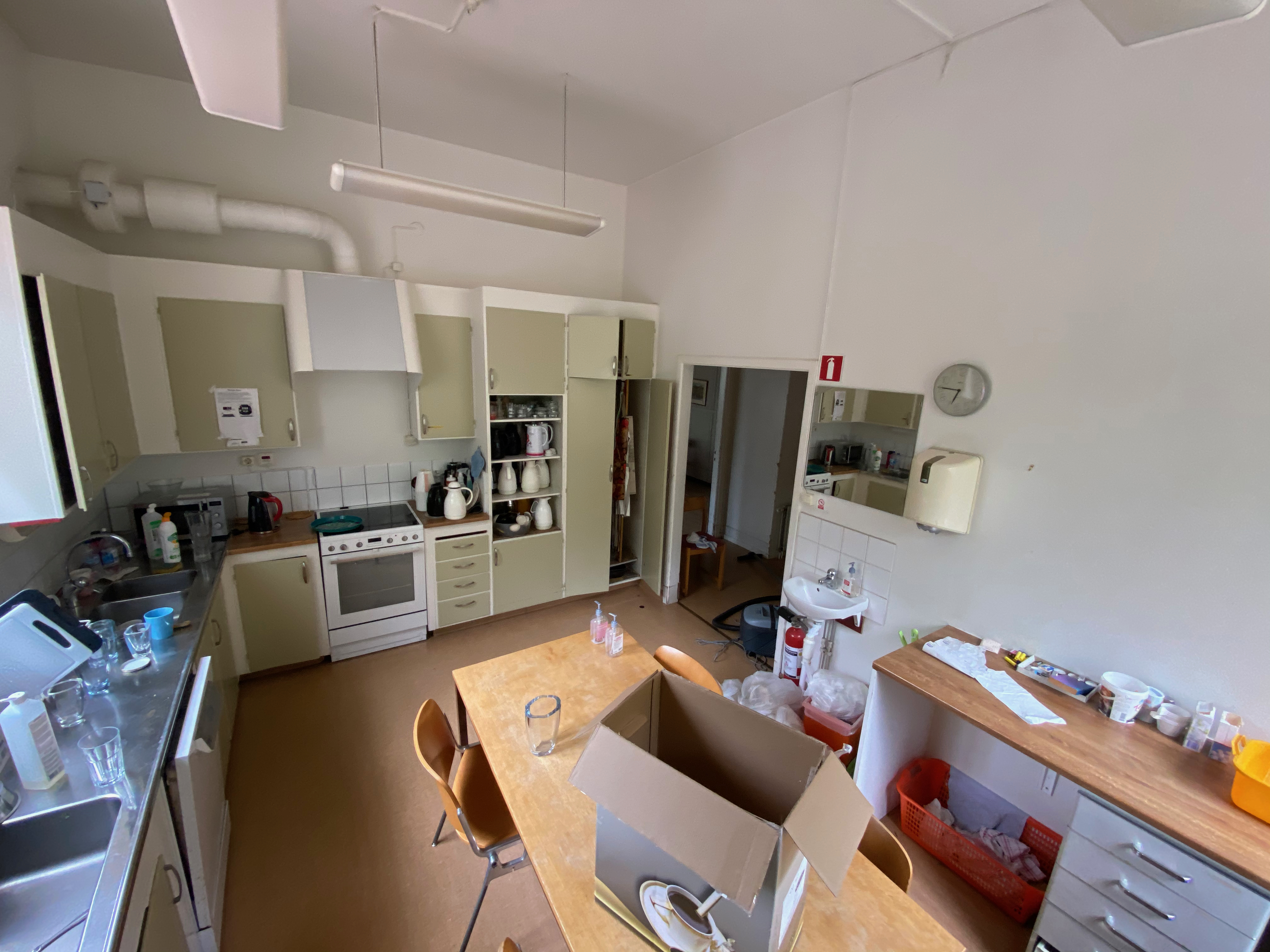 Köket från annan vinkel med spis och kylskåp