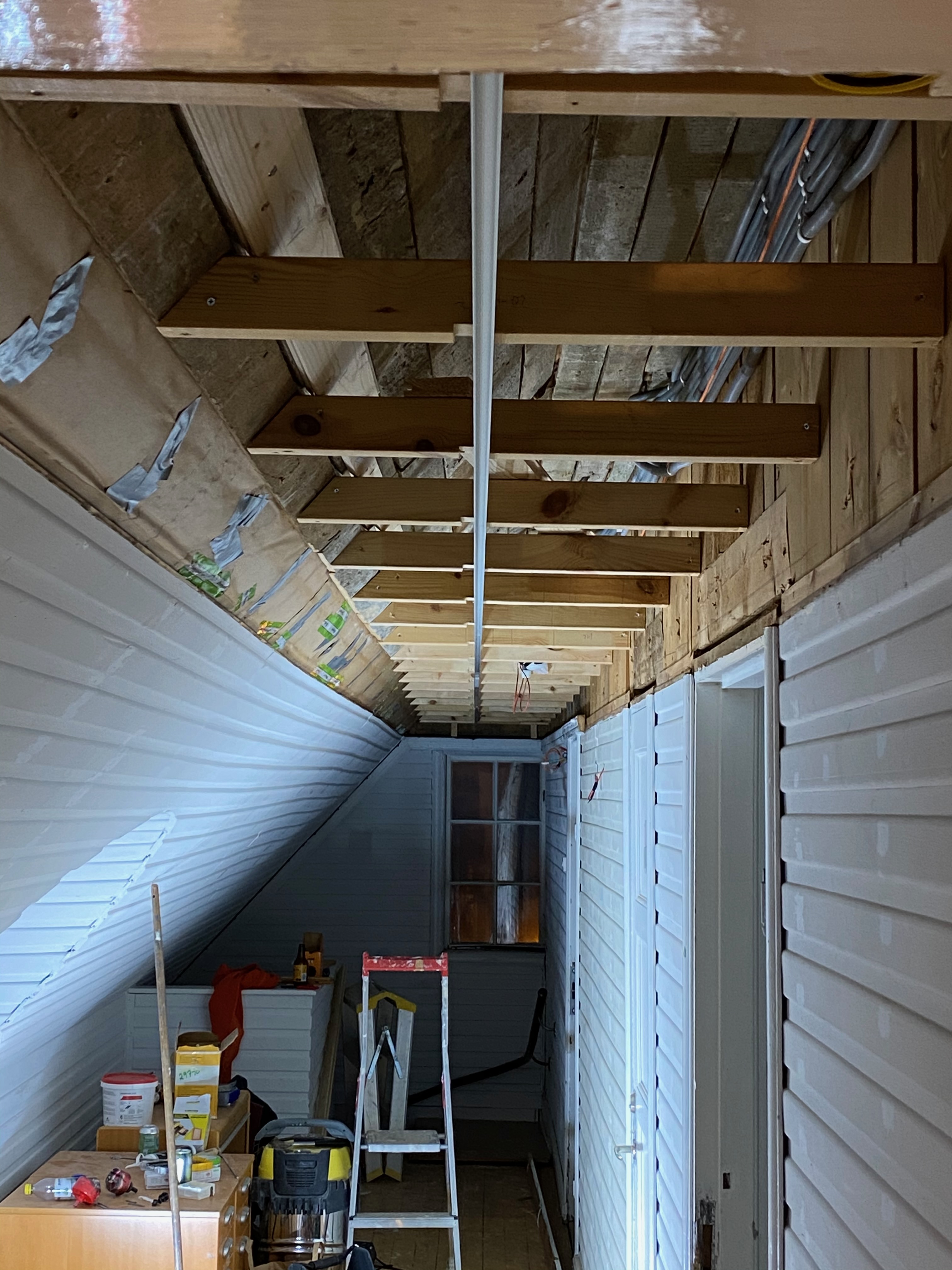 Vindsvåning under renovering med blottlagda takstolar