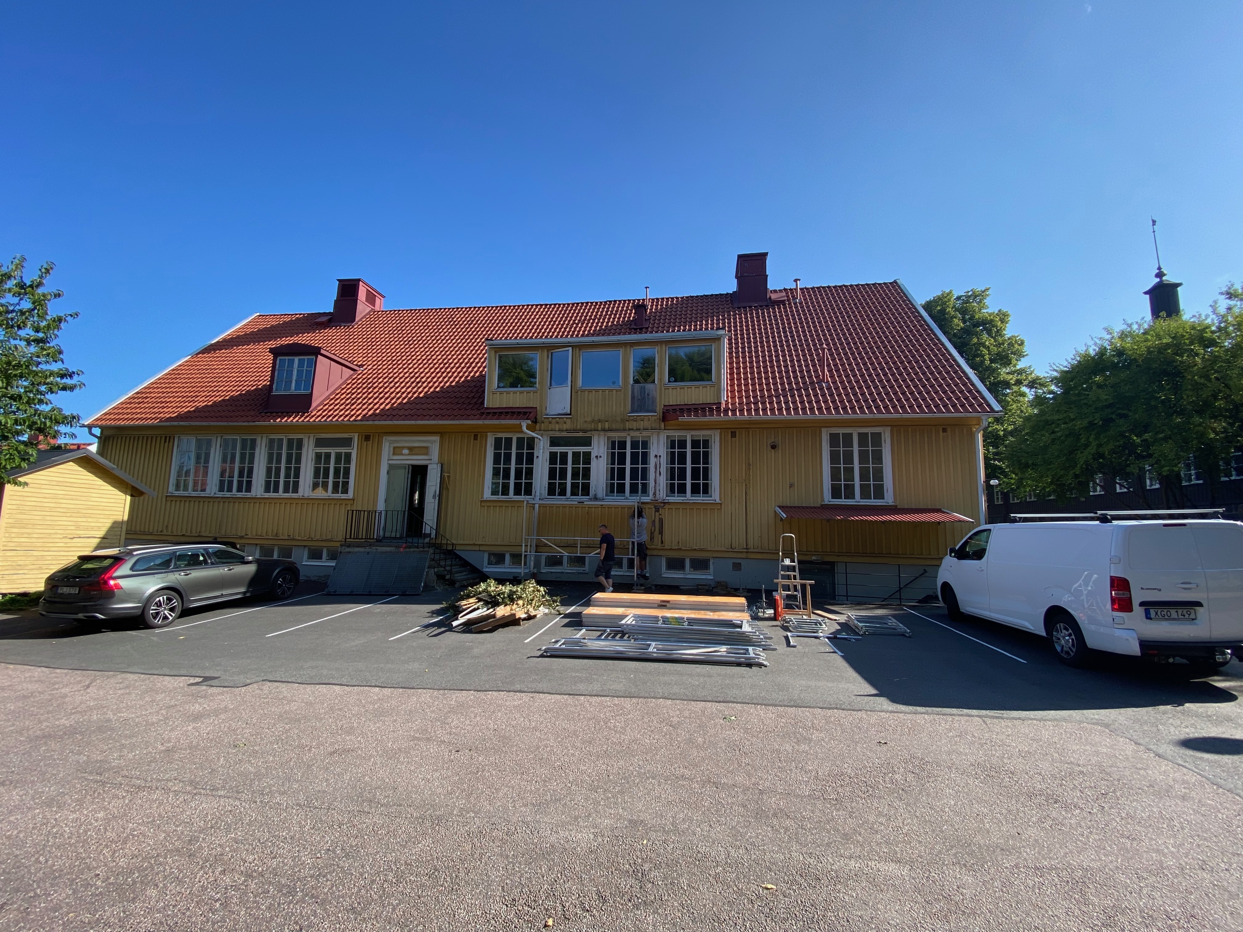 Villan med byggställning, stege och virke på parkeringen